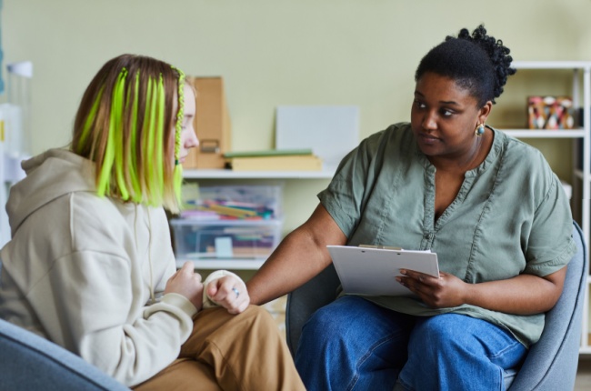 female social worker supporting sad teenage girl during her difficult situation at school