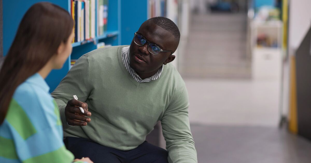 mental health therapist talking to teenage girl in college library